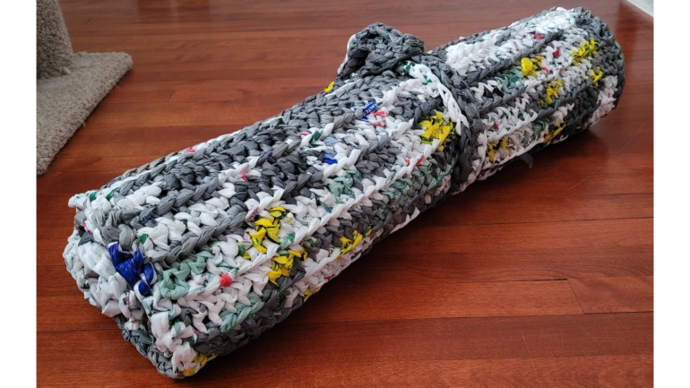 A finished sleeping mat created by Abbi Johnston wrapped up with the handle.