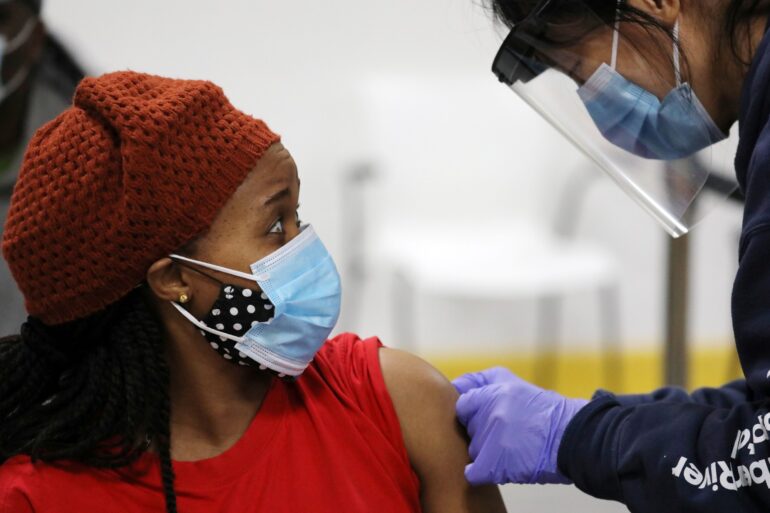 A woman is bandaged after her inoculation by a health worker from Humber River Hospital during a vaccination clinic for residents 18 years of age and older who live in coronavirus disease (COVID-19) "hot spots" at Downsview Arena in Toronto on April 21, 2021.