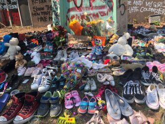 Shoes and flowers laid beneath Egerton Ryerson statue at Ryerson University. The shoes represent the children's that didn't make it home.