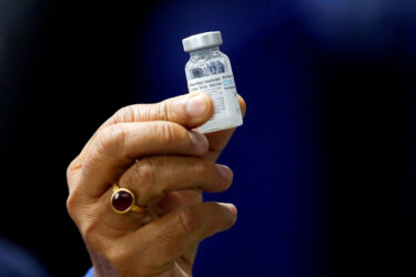 Indian Health Minister Harsh Vardhan holds a dose of Bharat Biotech's COVID-19 vaccine called COVAXIN, during a vaccination campaign at All India Institute of Medical Sciences (AIIMS) hospital in New Delhi on Jan. 16.