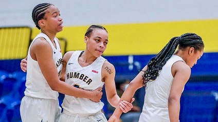 From left, Miea Campbell-Johnson, Brittney English and Kia Watt celebrate during a game against St. Lawrence on Feb. 26.