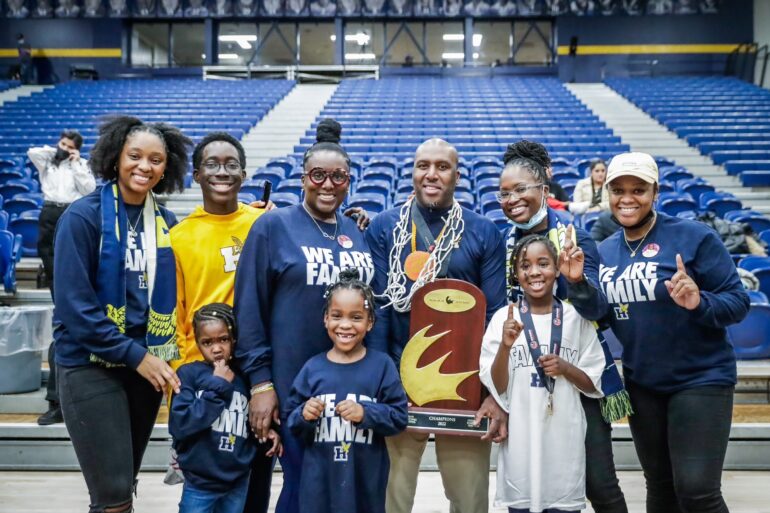 Omar Miles poses with the CCAA trophy and family. Miles says he is a family man, and his family played a key role in motivating and supporting him.