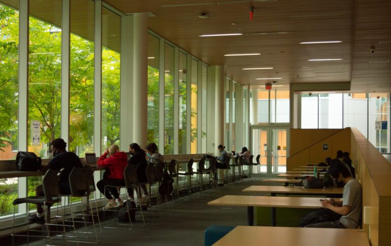 Students working in a study area in the hall of gratitude at Humber college's north campus.