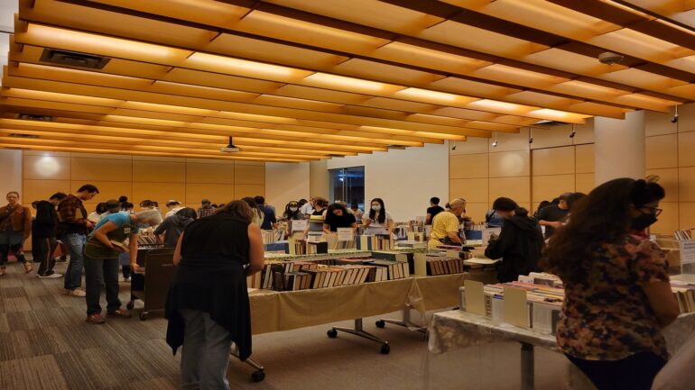People searching through the stocks of books available in the Friends of the Library Treasure Book Sale.