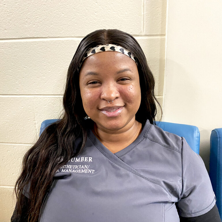 Denise Brown, one of the interviewees, is smiling at the camera in her program's uniform.