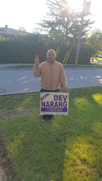 Dev Narang, one of the candidates for Etobicoke North, standing in front of his election sign.