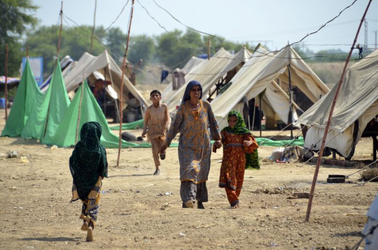 Families take a refuge at a camp after leaving their flood-hit homes, in Jaffarabad, a district of Baluchistan province, Pakistan, Wednesday, Sept. 21, 2022.