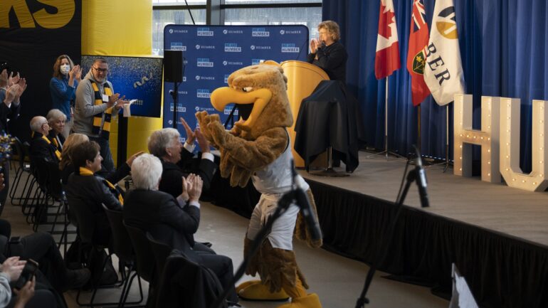 Humber Hawks mascot, Howie, high-fives the crowd in the Barrett Centre for Technology Innovation after Dr. Ann Marie Vaughan, President and CEO of Humber College, announced the $30 million donation by the Barrett Family Foundation.