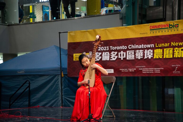 Chanel Zhang plays the Chinese lute on stage.
