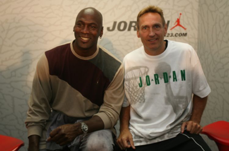 Dave Hopla seated next to Michael Jordan at a Jordan event. Hopla has coached the likes of Michael Jordan, Kobe Bryant, Ray Allen, Zion Williamson, and many more.