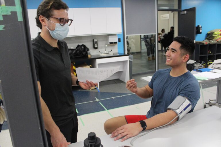 From left to right, Faculty of Health Science and Wellness professor, Joseph Cicchillo speaking with Pre-Service Firefighter Education and Training student, Kristofer Guinto about his blood pressure test results. The test took place during an IPE event involving Exercise Science Lifestyle Management students collaborating with Pre-Service Firefighter Education and Training students for their treadmill test.