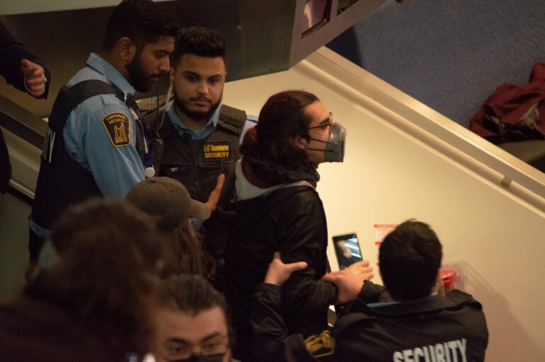 Protestor being escorted out of Wednesday's budget meeting, shouting for Tory's resignation.