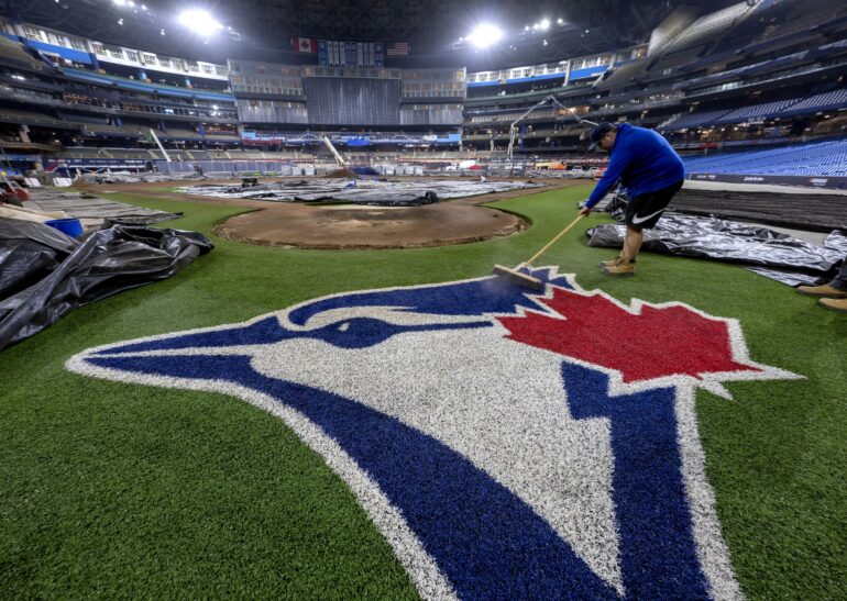 Toronto Blue Jays grounds crew member Tyler Holmes sweeps the team logo in the middle of the Rogers Centre renovation in Toronto on Tuesday January 17, 2023.