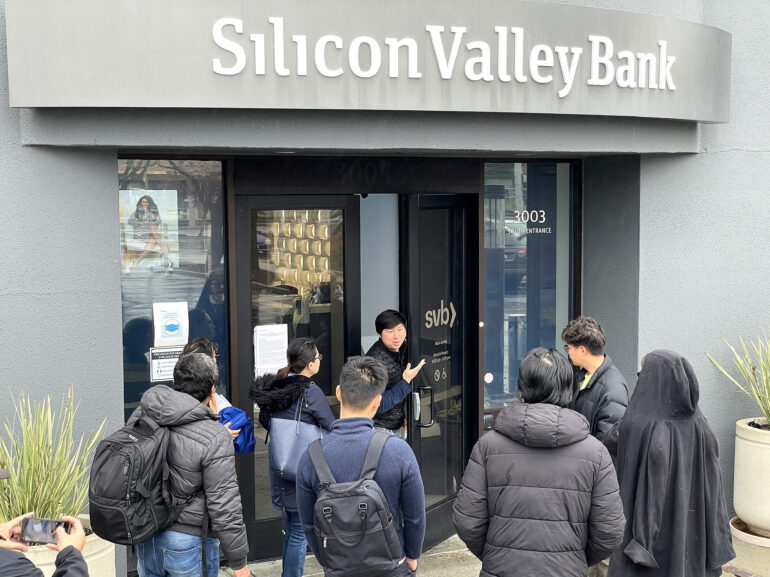 People are waiting outside the shuttered Silicon Valley Bank headquarters in Santa Clara, California.