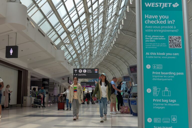 Travellers wandered around the WestJet kiosks to get the checked in at Toronto Pearson Airport, on May 19, 2023.