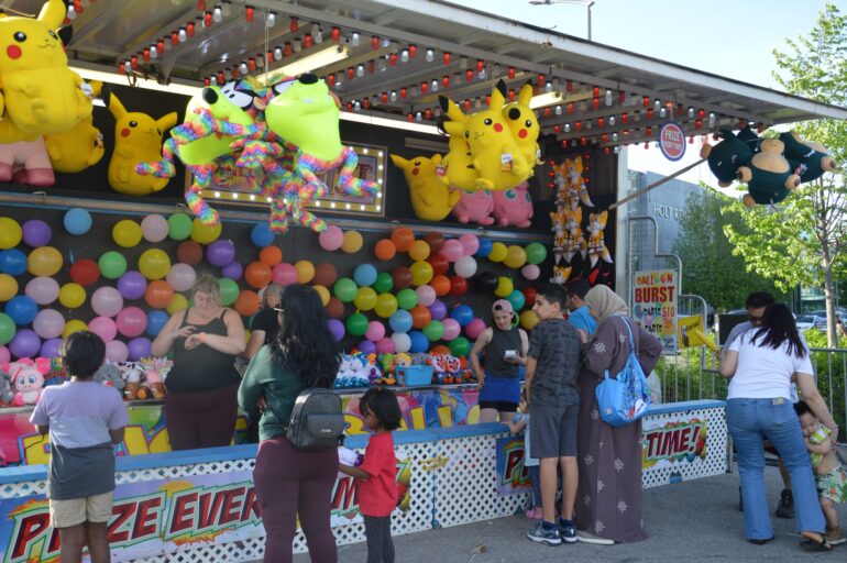 Carnival booth where attendees can pop balloons to win prizes.
