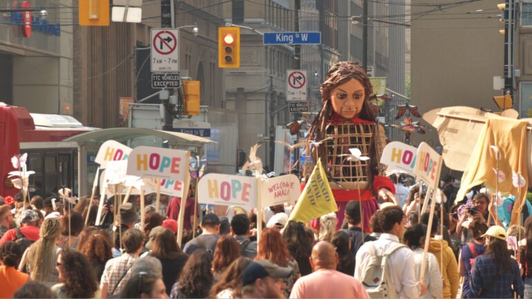 The 12-foot tall puppet was towering above a huge crowd on the streets of downtown Toronto on Wednesday.