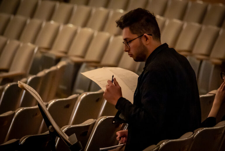 Luis Ramirez taking notes while TSO rehearsed his composition Picante on June 14, 2023.