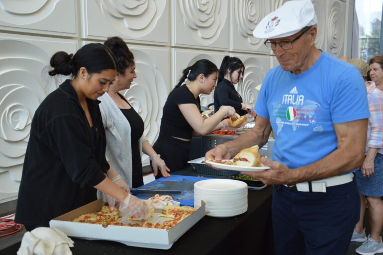 Guests at Brampton City Hall grabbing authentic Italian food at the Italian Heritage Month celebration.