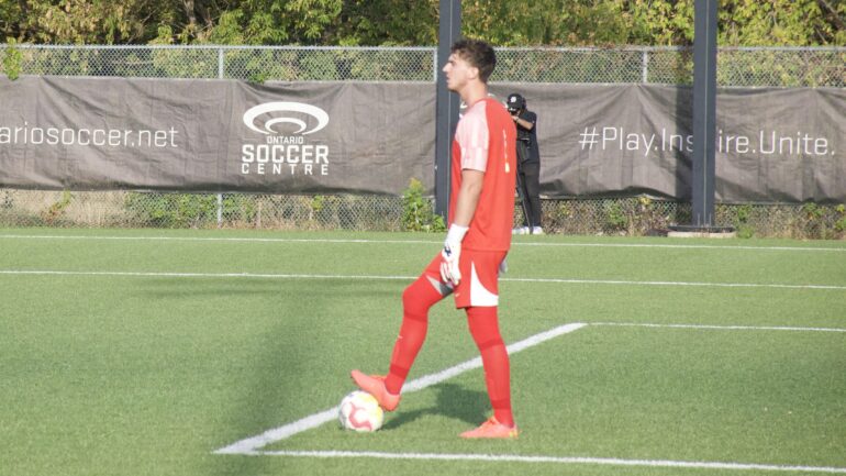 Soccer goalkeeper with ball at his feet