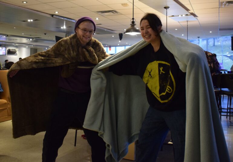 Humber students posing while wearing blankets at Game Jam 2023.