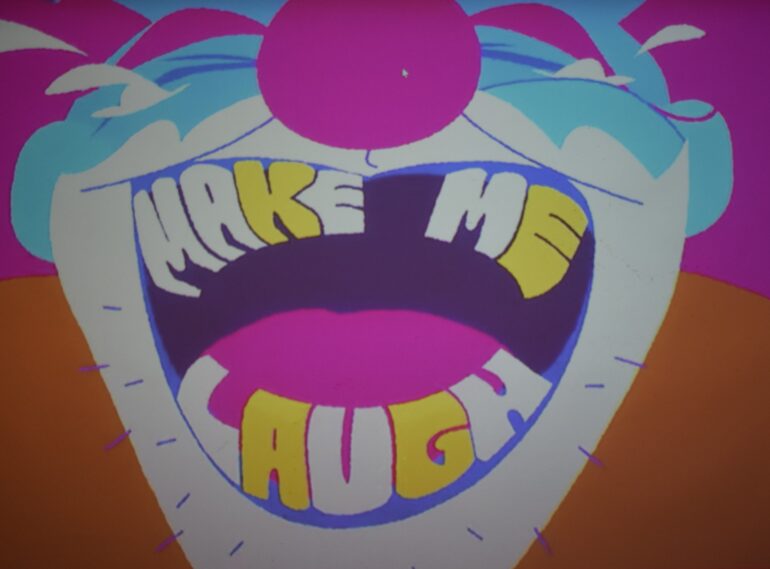 Photo of the screen presenting the theme for GGJ 2024, called "Make Me Laugh".