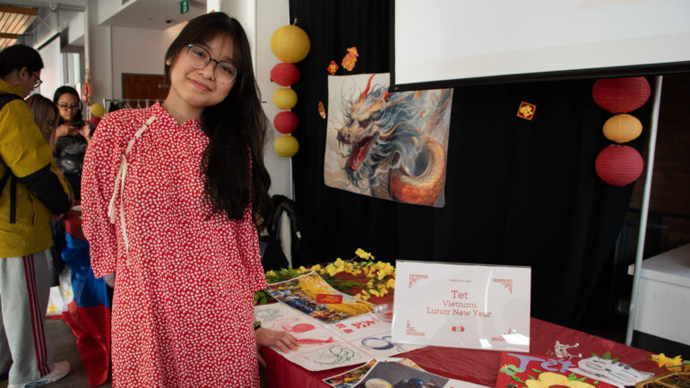 Nhi Luu, a second-year Bachelor of Behavioral Science student from Vietnam, stands beside the Tet Vietnam Lunar New Year booth on Feb. 8.