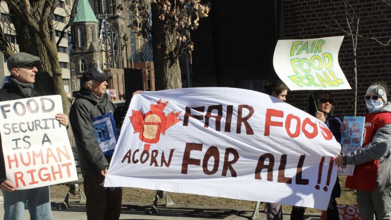 Members of ACORN holding placards and a banner at the protest site on Bloor Street last Saturday.