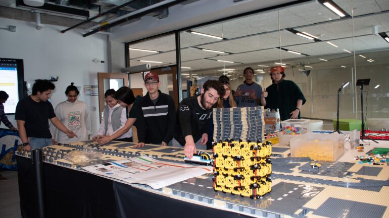 A group of students playing with and building Lego bricks.