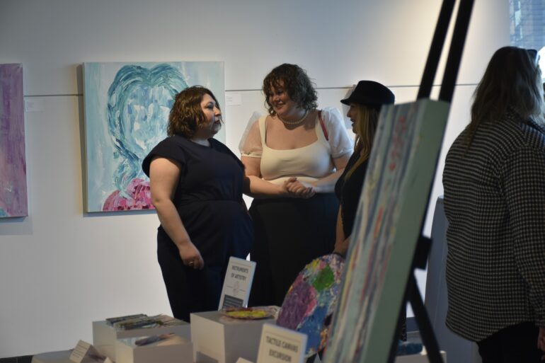 Three people gathered in the University of Guelph Humber's art gallery.