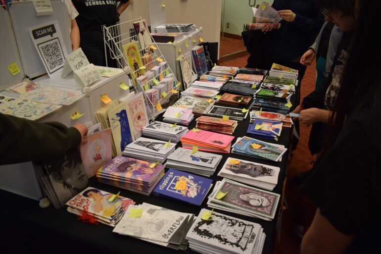 A table of works from students from the Ontario College of Art and Design University (OCAD U) at TCAF 2024.