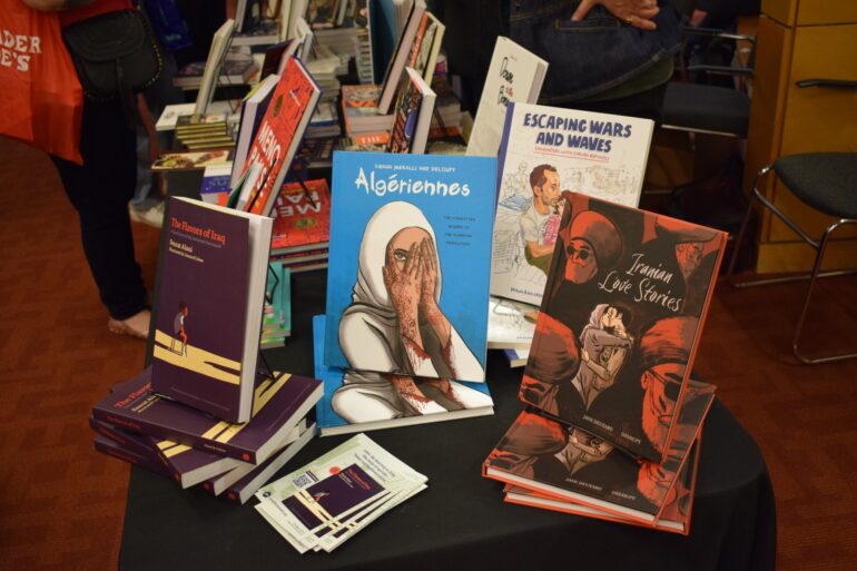 A photo of a table at TCAF 2024 with graphic novels about war and peace in Iran, Syria and Iraq.