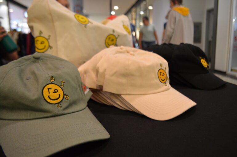 three hats with graphic designs lined up on a table.